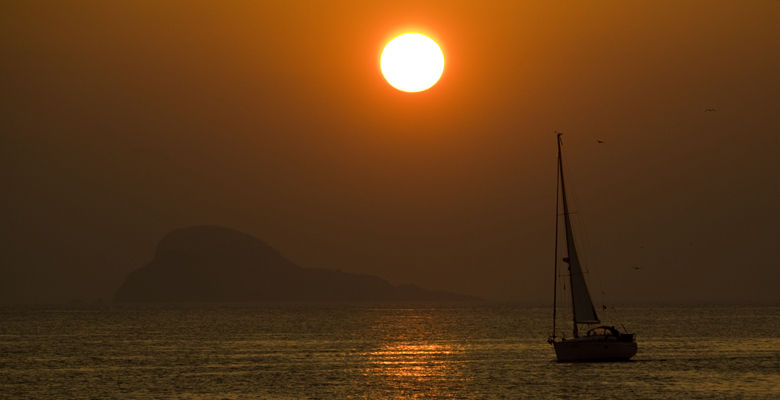Puesta de sol en el entorno de la ría de Avilés con la isla de la Deva al fondo