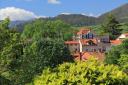 View of the red roofs of the houses of Colombres surrounded by trees and mountains in the background