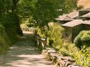 A narrow path next to some stone rural houses with slate roofs
