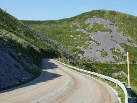 A mountain road ascends a slope near the top of a mountain