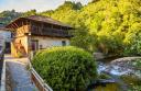 A typical Asturian granary next to a cobbled path and a stream