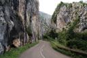 A road runs through a gorge between high rocky walls