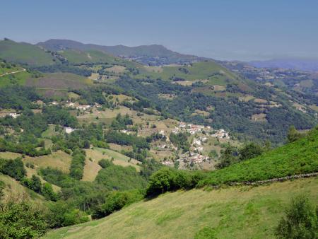 Panoramic view of green hills and mountains with a small town in the center