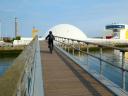 Cyclist crossing the Avilés estuary in front of the Niemeyer building