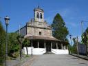 Old rural stone church with a bell tower and a wide entrance porch