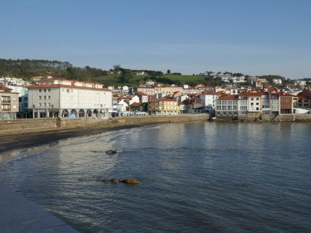 View of a coastal town facing the bay, with colorful houses and hills in the background