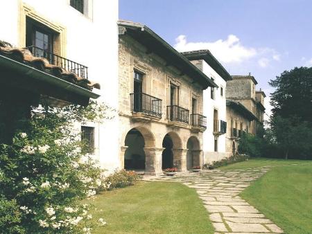 A white stone palace with arches and balconies and a paved path
