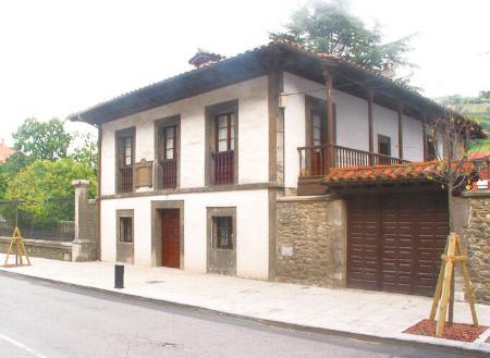 Facade of a two-story Asturian mansion with a side balcony