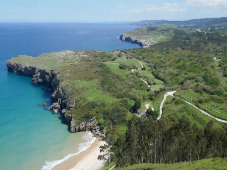 Vista desde lo alto de la costa asturiana con acantilados, una cala y abundante vegetación