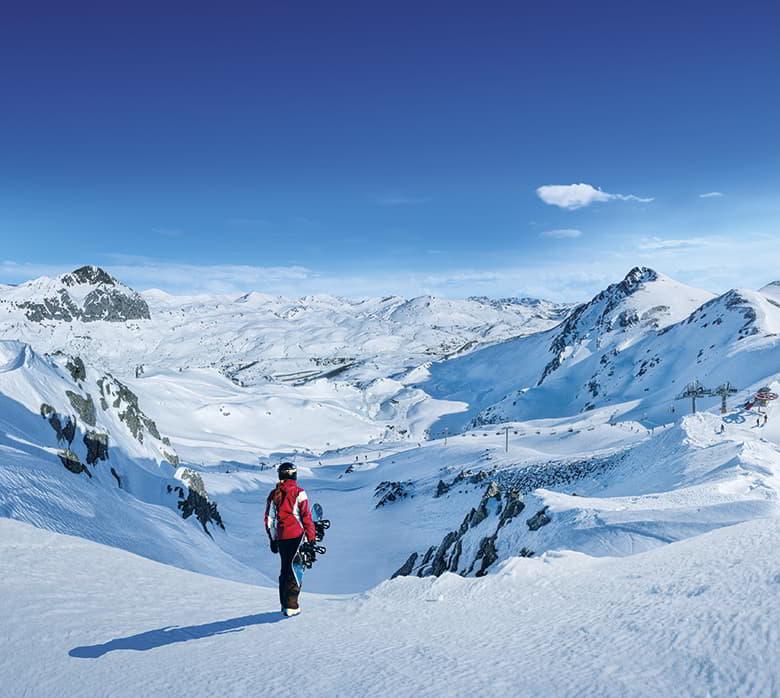 Image of a girl surrounded by snow and ready to snowboard in Fuentes de Invierno.