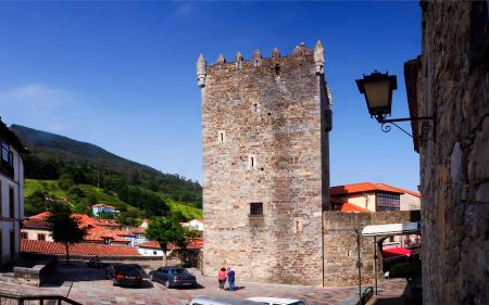 Old stone tower with battlements in a square with cobblestone ground