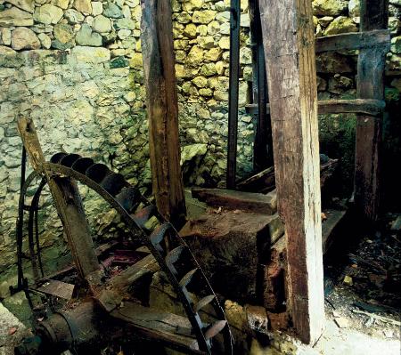 A crude wooden machine for felting pieces of wool with an old hydraulic wheel
