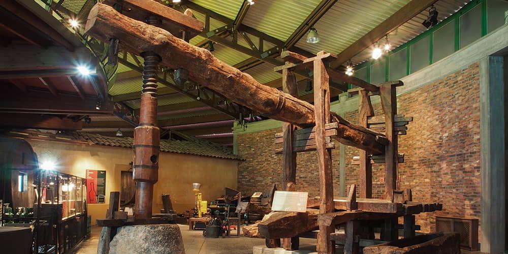 Counterweight press in the foreground inside the Cider Museum.