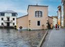 Hikers next to the Santa Eulalia de Oscos Town Hall on a rainy day.