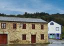Stone and slate house with windows and wooden gate in Santa Eulalia de Oscos.