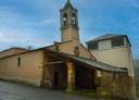 Church of Santa Eulalia de Oscos with tower and stone entrance portico.