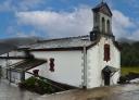Church of Doiras, a white church with a belfry and red details, in a rural setting.
