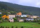 Panoramic view of the village of Doiras with colourful houses and forest background.