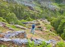 Hiker exploring the remains of the Pendia Hillfort surrounded by nature.