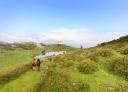 Hikers approaching the Monsacro chapel by a lagoon