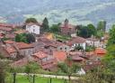 Panoramic view of the village of Alevia with reddish roofs between mountains.