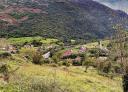 Panoramic view of the valley of Mier between mountains and green fields.