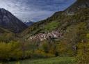 Pendones village between green mountains and partly cloudy skies.