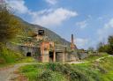 Industrial ruins with chimney on hillside