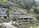 Stone houses in the village of As Veigas surrounded by forest