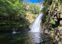 Person swimming in the pool below the Cioyo waterfall