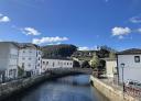 Bridge over the river Eo with houses and hills in the background in Vegadeo
