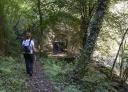 Hiker walking through the forest towards the old Esva hydroelectric power station.