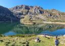 Senderistas disfrutan de las vistas de un lago de montaña y el valle  en un día soleado