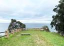 Recreation area with wooden bench, information signs and sea view