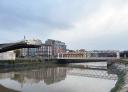 Historic buildings and a bridge over the estuary, reflecting in the water