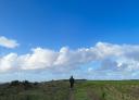 Lone hiker on a route with sweeping views of sky and horizon