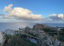 Panoramic view of steep cliffs and blue sea from a lookout point