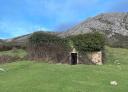 Old rural stone building half-hidden in the vegetation