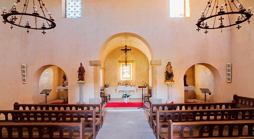 The interior of the pre-Romanesque church of Santa María de Bendones in Oviedo, Asturias, with the central nave and altar.