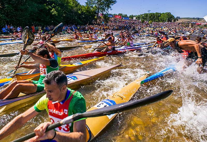 The start of the Descent of the Sella in Asturias, showing numerous participants paddling hard on the river.
