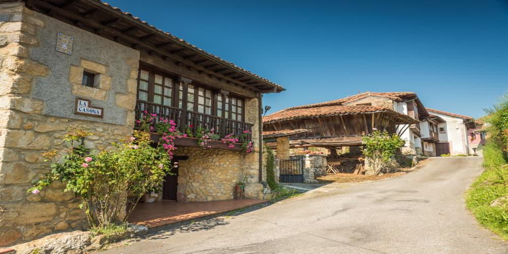 Rue rurale à Ceceda avec maison traditionnelle en bois à couloir, panneau 
