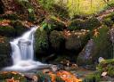 Waterfall between moss-covered rocks in the Puerto de Piedrafita pass