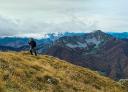 Lone hiker climbing up steep rocky terrain with spectacular views