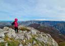 Hiker on the summit enjoying the immense view of the landscape.