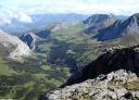 An impressive panoramic view of valleys and rocky peaks from the summit