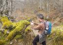 Hiker takes a picture of nature. Moss growing on the trunk