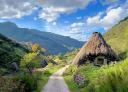 Road winding through mountains and thatched huts, scenic route
