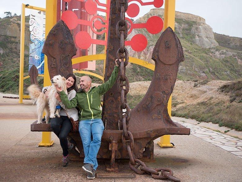 Photo of a couple with their dog outside the Salinas Anchor Museum, located in the municipality of Castrillón.