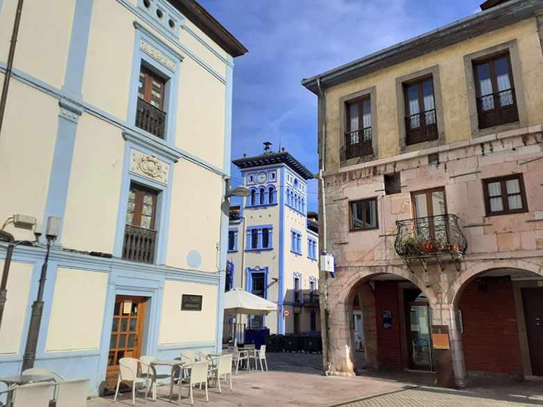 Image of a corner of the Grau/Grado Historic Site with the Town Hall building in the background.