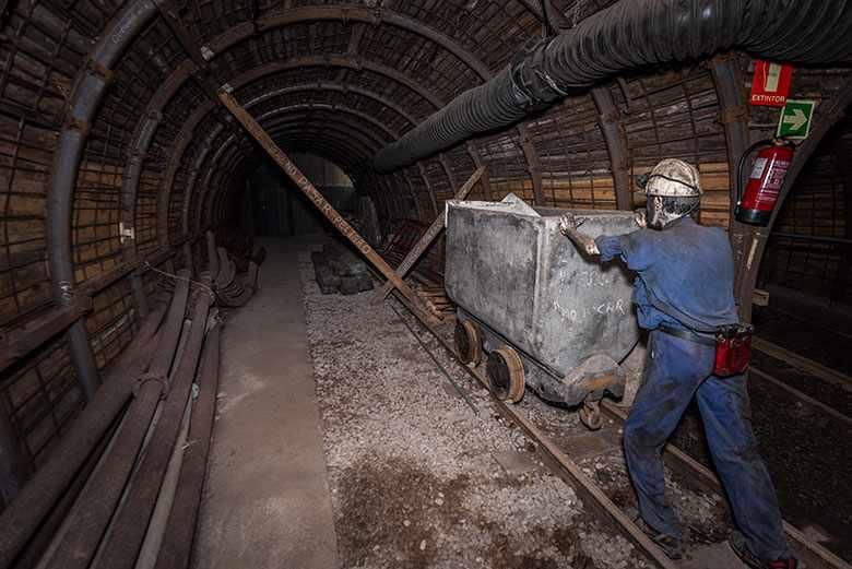 Image of the interior of the Museum of Mining and Industry of Asturias showing a miner pushing a wagon.